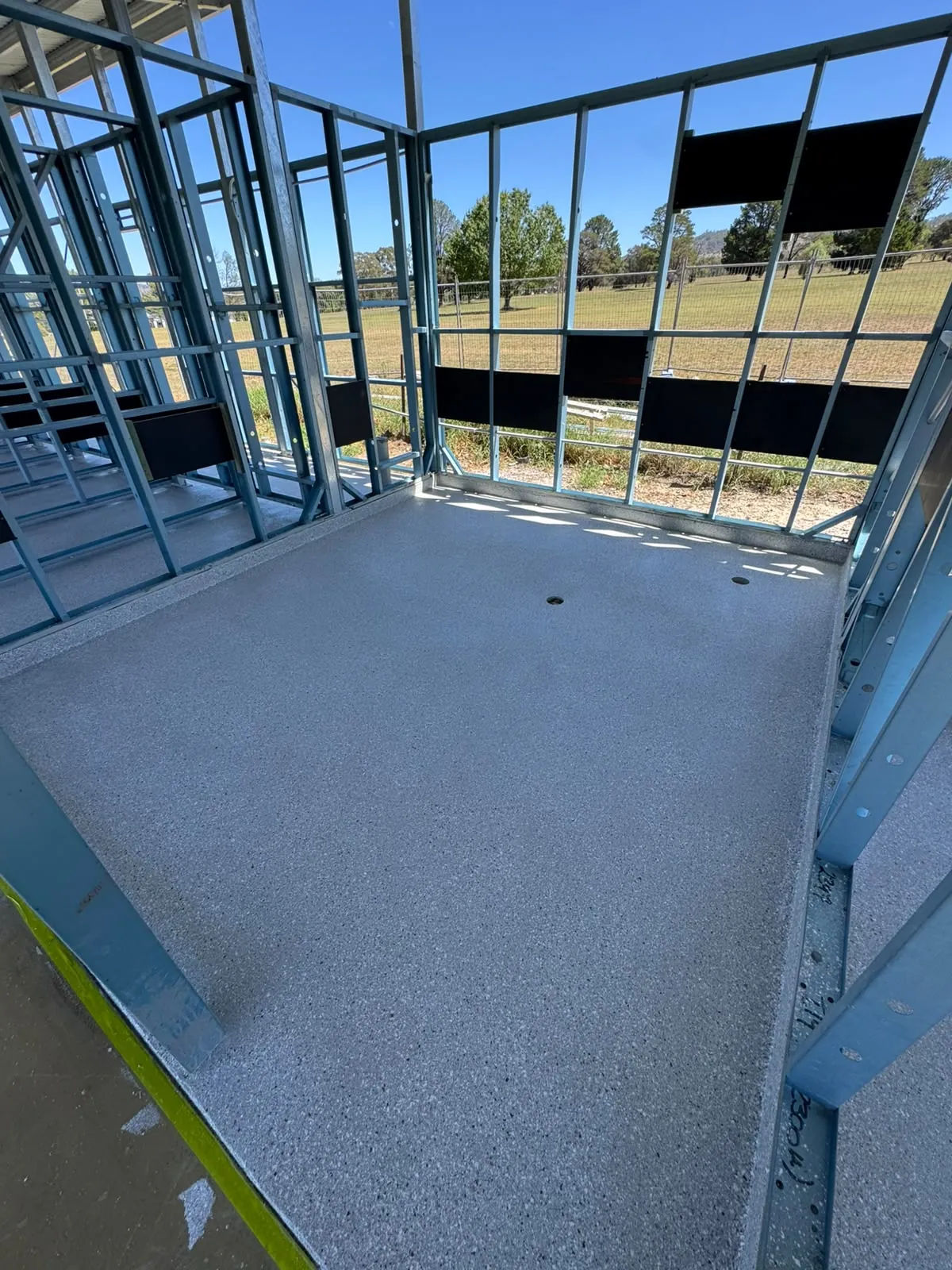 Decorative flake floor in a steel-framed room under construction