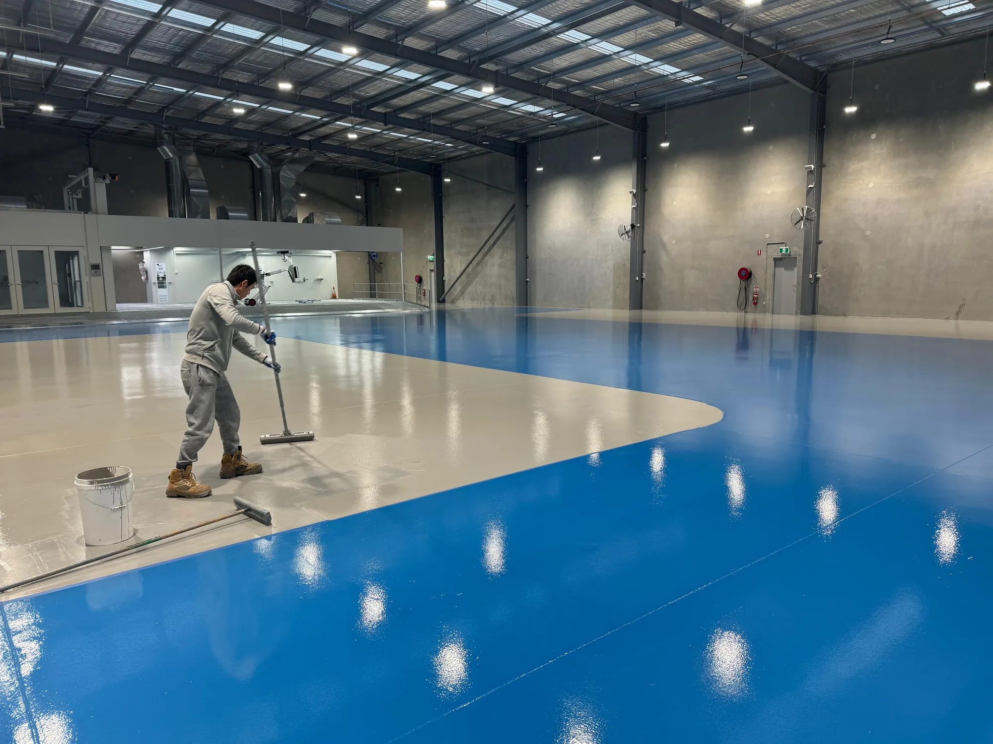 Master Finish installer applying epoxy coating at the RepairHub project